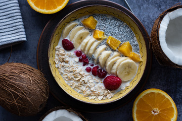 Oatmeal with chia seed, bananas and oranges served in a bowl