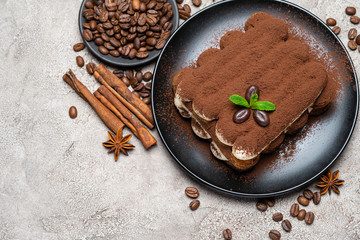 Classic tiramisu dessert on ceramic plate on concrete background