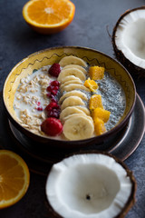Oatmeal with chia seed, bananas and oranges served in a bowl