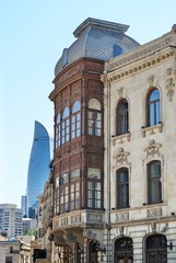 Fototapeta na wymiar The Old City classic buildings in Baku with modern Flame Towers background on a sunny day. Azerbaijan