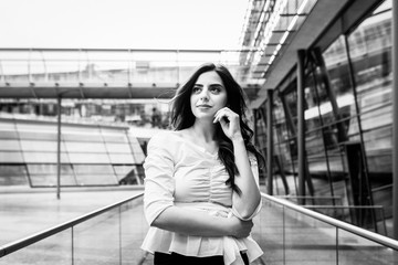 Beautiful attractive woman wearing white blouse and black pants look in camera