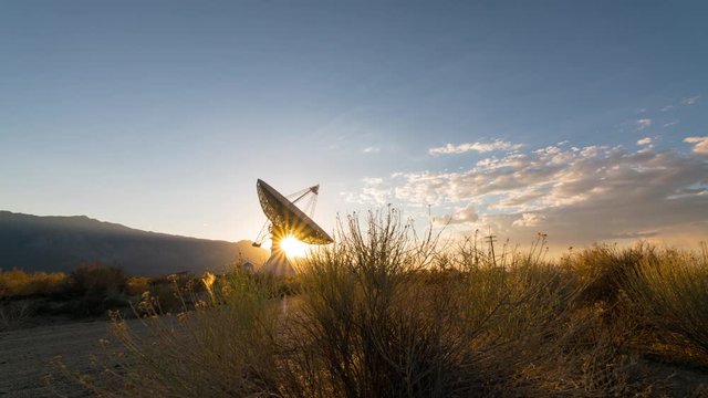 Time lapse tracking shot of sun setting behind radio observatory in Eastern Sierra, California