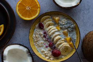 Oatmeal with chia seed, bananas and oranges served in a bowl