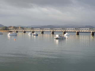 Fototapeta na wymiar Boats And Rail Bridge At Tauranga Harbour