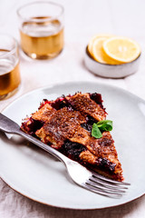 Slice of Delicious Homemade Berries Honeysuckle Pie on beige linen tablecloth. Selective focus