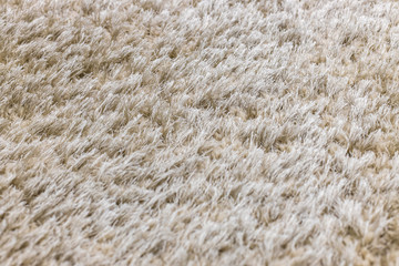 The texture of a long pile of gray artificial carpet. Focus with a shallow depth of field.