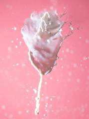 Splashing milk on a pink background.