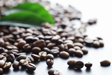 Obraz premium Bag of coffee. Coffee beans roasted on the table. Coffee beans with green leaves for cooking.