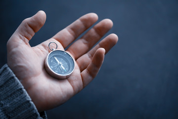Travel concept. Magnetic compass in the hand. Retro navigator in hand a map and airplane background. Adventure Background.