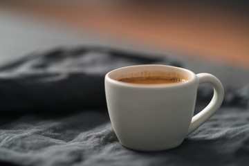 hot espresso in white cup on linen cloth with copy space