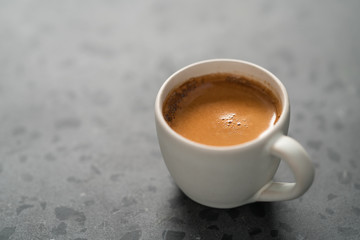 hot espresso in white cup on concrete background with copy space