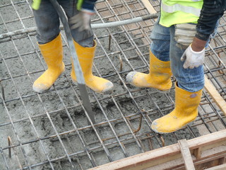 SELANGOR, MALAYSIA -JUNE 18, 2016, : Construction workers using a concrete vibrator at the construction site to compact the concrete slurry that pours in the form work. 