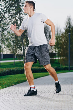 sports man in sneakers shorts and a t-shirt running in the park outdoors fitness