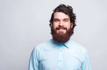 Portrait of bearded man in shirt looking confident at the camera.