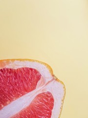Red ripe juicy grapefruit in a cut on a yellow background view from above. The concept of diet and healthy eating. A place for text. 