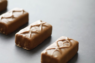 Chocolate bars on a black background in backlight. Chocolate with filling. Sweet sweets for snack and tea.