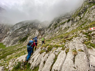 Fototapeta premium Man Hiking to the top of Germany with a stunning view to the alpine rocks in Germany