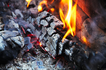 Glowing embers in hot red color, abstract background. The hot embers of burning wood log fire....