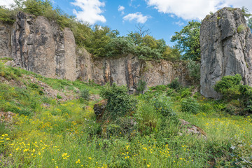 A Rock face with a pillar in front of it.