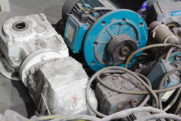 Old motor laid on the floor. The old motor is scrapped. Rusty old motor. Old electric cable