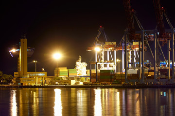 Fototapeta na wymiar view of the industrial port at night - ships waiting for loading and unloading, cargo transportation by sea