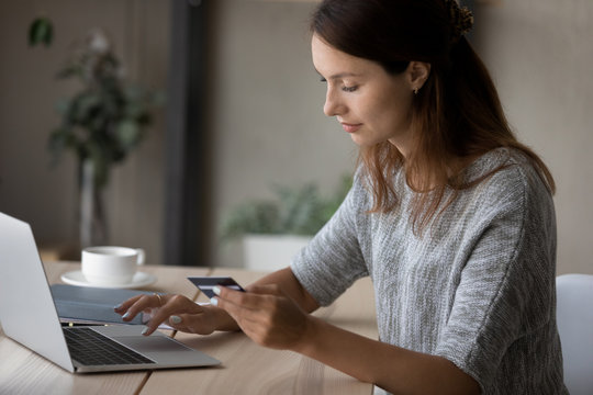 Young Caucasian woman sit at table make online payment or purchase using secure web banking system on computer, millennial female shopping on internet, pay bills with credit card on laptop on web