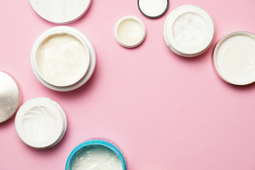 woman creams on pink flat background, face and body creams. flat lay. beauty and skin care concept