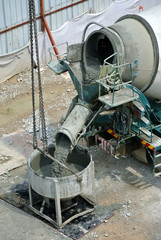 SELANGOR, MALAYSIA -JUNE 06, 2016: Concrete mixer lorry pouring wet concrete into concrete bucket. 