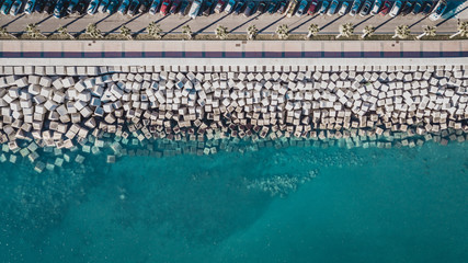 Fototapeta premium Aerial view of cement cube blocks protecting the shore from the waves in the port of Malaga, Spain.