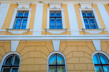 Windows reflecting the blue  sky on an old restored  historical building.