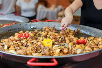 Delicious baked potatoes in iron pan with onion and bell pepper on fairs in Budapest