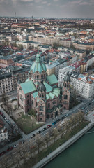 Fototapeta premium Aerial view of St. Lukas church and in the background Munich City in Bavaria, Germany.