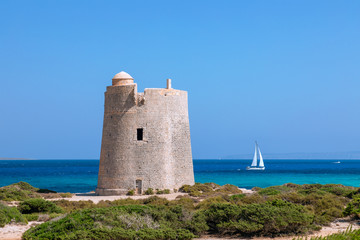Beautiful view of the old observation tower (Torre De Ses Portes) and sailing yacht off the coast...