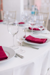 Elegant table setting for wedding celebration in restaurant. Vertical shot, light colors.