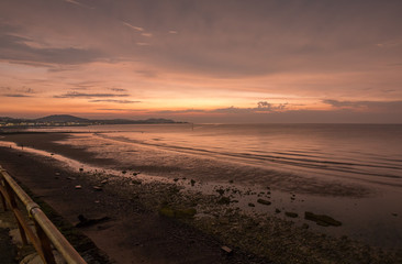 Summer evening at Colwyn bay, North Wales. Warm summer sunset and a rocky beach