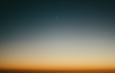 crescent moon in the turquoise sky and amazing sunset