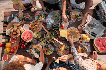 High angle view of group of people sitting at the table and have dinner they celebrating the...