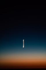Crescent moon in the multicolored sky and amazing sunset