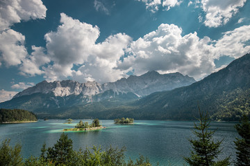 Sunny summer day on Eibsee lake with Zugspitze mountain range. Sunny outdoor scene in German Alps, Bavaria, Germany, Europe. Beauty of nature concept background.