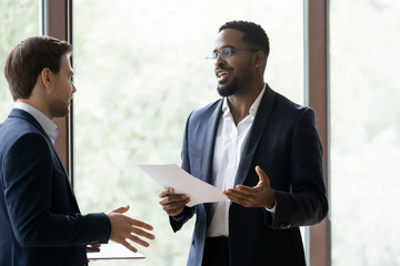 Positive african banker, consultant or finansial advisor convinsing caucasian customer in benefits...