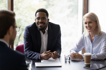 Inspired african businessman talking about benefits of his startup on meeting with potential...