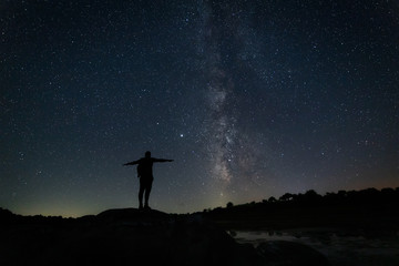 Night landscape with Milky Way and human silhouette.