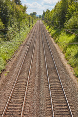 Fototapeta na wymiar Zwei parallel verlaufende Bahngleise an einem sonnigen Tag.