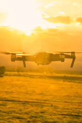 Man is enjoy playing control silhouette of flying drone on sky with sunset background