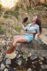 Young woman relaxing outdoor travel freedom lifestyle with mountains on background. Fashionable girl in  a mountain