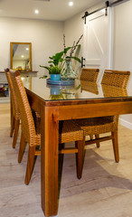 Bright dining room with a wooden table and rattan chairs.