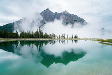 Spiegelung eines Berges in einem Bergsee in den Alpen in Tirol - 373248874