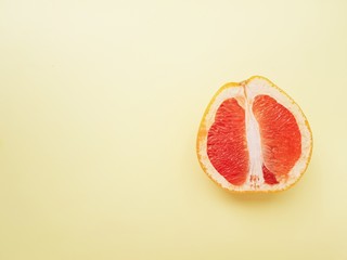 Red ripe juicy grapefruit in a cut on a yellow background view from above. The concept of diet and healthy eating. A place for text. 
