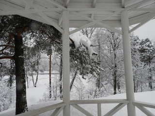 White Chinese style gazebo perched on a rock in winter in the snow