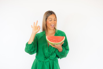 Beautiful woman in green dress with a watermelon smiling